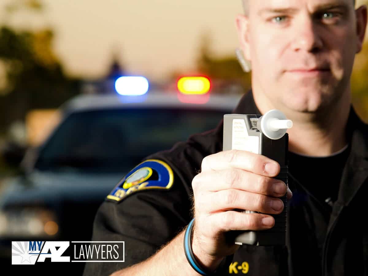 Arizona Police Officer Holding A Breathalyzer Test