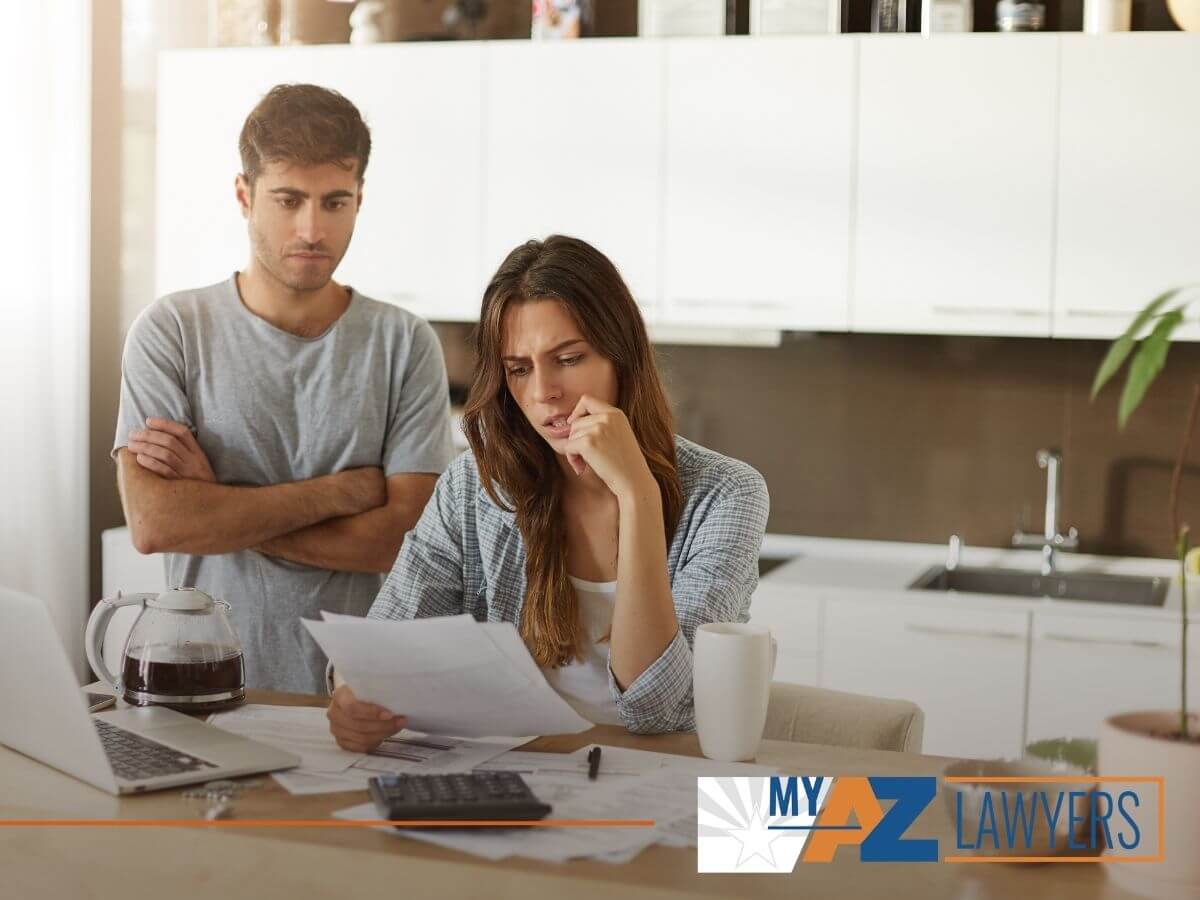 Married couple checking their bills trying to decide between bankrupcty and debt setllement with tips from My AZ Lawyers blog