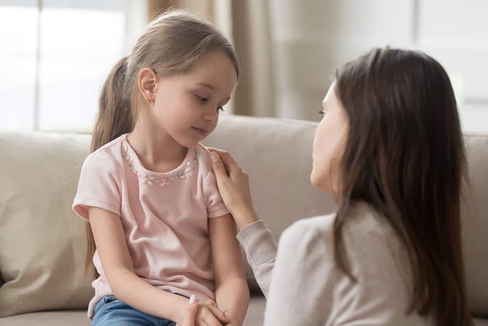 Mother talking with upset young girl