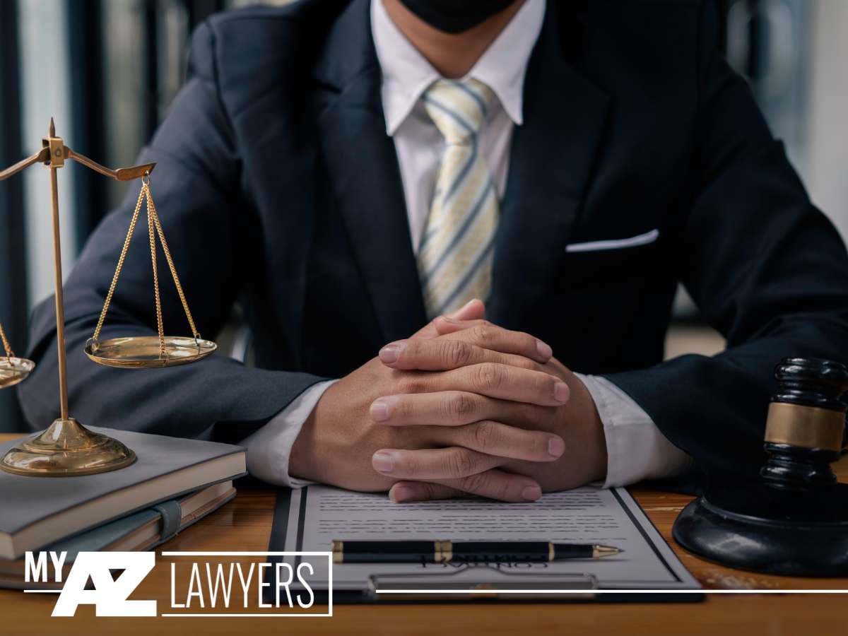 Lawyer seated at desk with scales of justice, representing legal services for Arizona cities considered the deadliest for car crashes